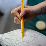 Rhian Malin decorating a mandala bottle in her workshop 2019